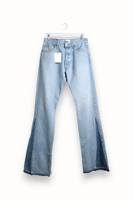 Light blue jeans with a tag on a white background