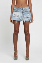 Person wearing a light blue denim skirt on a white background